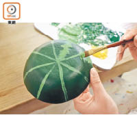 7.把整個碗的表面塗上深綠色塑膠彩，待乾。利用粉綠色塑膠彩在碗的表面畫成8份，再在每條線上畫出恍如西瓜的表皮紋，待乾。