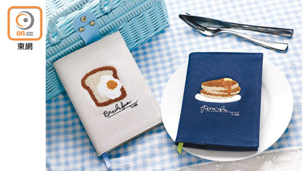 （左）Q-lia米色刺繡麵包手帳、（右） 深藍色刺繡班戟款$208/本（d）<br>日本品牌Q-lia的A6 Size手帳，採用布質封面套，配上精緻的早餐刺繡圖案，似要提醒晨早趕返工的用家，別忘了吃早餐的重要性。