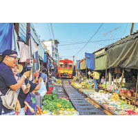 Maeklong火車鐵路市場讓你見識攤位火速「走鬼」讓火車駛過的奇景。