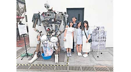 4位青年藝術家李浩延（左後）、（左前起）李樂嘉、黃珮詩及麥穎菁利用廢鐵和棄置物組成的作品《城市巨人》，他們希望透過巨人洗衣服的行為，讓大眾反思今時今日的香港，到底遺失了甚麼。