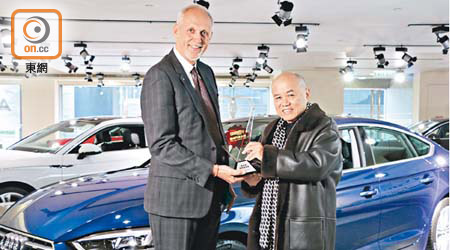 余錦基太平紳士（右）將「最卓越歐洲揭背車」獎座頒贈予奧迪香港董事總經理郝龍德（Lothar Korn）先生。