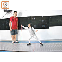 教練將劍直立後放手，小朋友要用弓步去快速握劍，以訓練正確姿勢及速度。