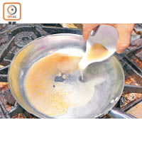 3. 將蟹湯及蜆水注入鍋中，加炸蒜煮滾。