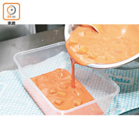 加入紅麴米水調校成橙紅色，加番薯及紅豆拌勻成黑糖年糕漿後分兩等份，一份注入膠模中蒸15分鐘。