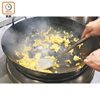 3. 雞蛋拂起，以慢火炒，凝固後轉至猛火，聞到蛋香後熄火。