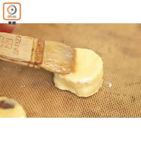 取出麵糰，搓平再摺疊2至3次，然後用模具切成厚圓形狀，面層掃上蛋白，以180℃焗17分鐘即成。