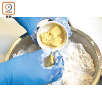 將250克低筋麵粉、海鹽和糖過篩，放入切粒牛油，利用指尖輕輕將牛油和麵粉混合成沙粒狀。
