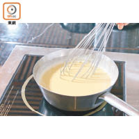 3. 坐熱的蛋黃注入杧果糖水中拌勻。