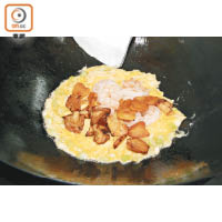 4. 炒滑蛋至6成熟，放入所有材料同炒，蛋汁凝結後熄火放菌即成。