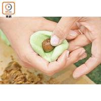 粉糰壓扁後釀入椰糖粒，包裹後搓成糯米球。