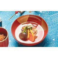 御椀<br>以鶴菜、蘿蔔、雞肉、菇菌和柚子等煮成的年糕湯，加入金箔作裝飾。