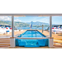 大型玻璃游泳池旁邊設有多張躺椅，方便乘客享受日光浴。
