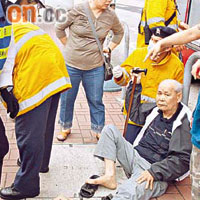 老夫妻跌倒受傷，分別坐於行人路兩旁，救護員到場協助二人治理傷勢。	（左錦鴻攝）