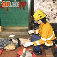 消防員為其中兩名男女傷者急救。	（周亮恒攝）