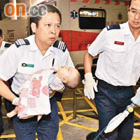 救護員抱着命危男嬰送院搶救。	（周亮恒攝）