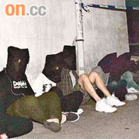 被捕黑漢全部蒙頭坐於地上接受警方盤查，左四為黑幫高層男子。	（李健瑜攝）