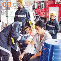 沙田被滾油灼傷手臂的廚師，由消防員檢查傷勢。	（吳子豪攝）