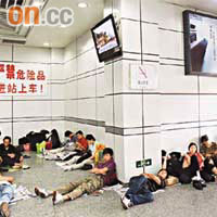 許多候車乘客在廣州火車站舊站席地而「睡」，乘客之間經常會有身體接觸。