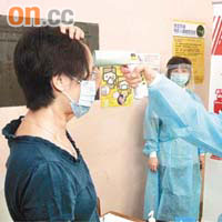 流感診所分流站護士為病人量體溫。