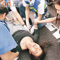 被的士撞傷的女子倒地不起，女途人在旁安慰。	（冼耀華攝）
