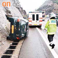 私家車撞向山邊後翻側。（黃君堡、曾紹良攝）