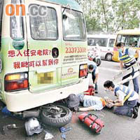 肇事電單車壓於小巴的車底，受傷鐵騎士由救護員急救。	（胡德威攝）