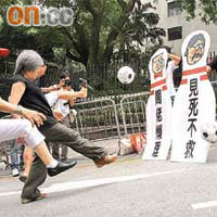 遊行人士把足球用力踢向紙製保齡球樽，宣洩對政府的不滿。（胡耀威攝）