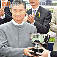 陳振彬（前排左）隻愛駒「傳奇快車」爆大冷，佢從馬會大董李國棟（前排右）手中接過「香港國際馬匹拍賣會五月挑戰賽」冠軍盃。	（徐家浩攝）