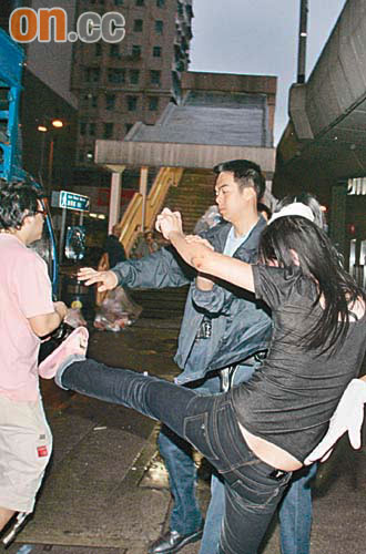 醉酒婦人起飛腳踢向記者。 （趙健圖攝）