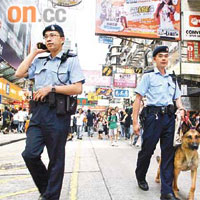 警員攜警犬於旺角鬧市巡邏。	（張琦攝）