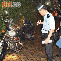 警員檢查其中一輛肇事電單車。（周亮恒攝）
