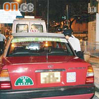 遇劫的士司機在車旁協助警方調查。	（左蘭慶攝）