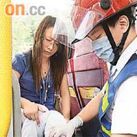 被玻璃碎片濺傷的女乘客，由救護員檢查傷勢。	（葉嘉文攝）