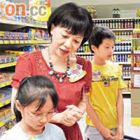 劉燕卿（中）帶兩位小朋友去超市掃貨，親自傳授格價心得。	（嚴少阡攝）