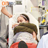 疑食物中毒的女子，由救護員以擔架床送院。	（周宏杰攝）