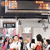 乘客在紅磡站月台久候列車，不時抬頭觀看列車開出時間。（鍾麗珊攝）