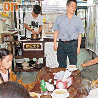 鄭記士多老闆鄭汝雄與客人分享沖奶茶心得。