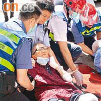 救援人員替受傷倒地的老夫婦急救。（李子強攝）