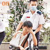 救護員將受傷男乘客推入院治理。	