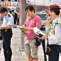 肇事貨櫃車司機（中）在現場協助調查。