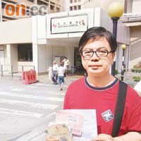 陳先生手持母親的醫療文件，要求屯門醫院交代事件。