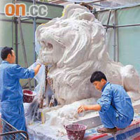 滙豐總行門外，銅藝師傅小心翼翼地將白色硅膠塗在銅獅「史提芬」身上，為銅獅子倒模。	（溫國佳攝）