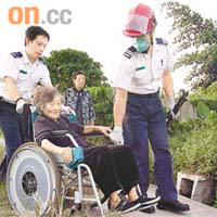 救護員用輪椅送墮渠的鄧婆婆到醫院。