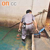 職員將水泵放入水池內，吸走積水。	（周景文攝）