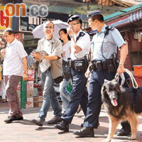 警員帶同警犬在街上巡邏。	（林少權攝）