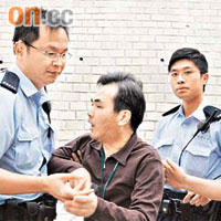 弱視男子情緒激動要參加旅行，警員在旁勸解。	（曾志恒攝）