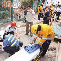 受傷的地政總署丈量員由救護員急救，圖右為地坑。	（趙瑞麟攝）