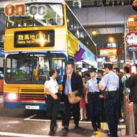 外籍警官（箭嘴示）欲乘巴士離去不果，被警員帶走。