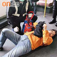 婦人倒臥巴士下層地台，由救護員檢查。	（吳子生攝）