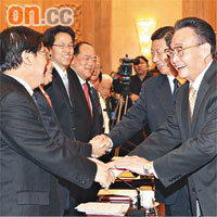 吳邦國（右一）、習近平（右二）在北京人民大會堂，與出席澳門《基本法》實施十周年座談會的來賓握手。